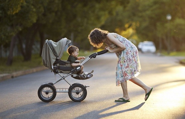 mom pushing a baby in a stroller 
