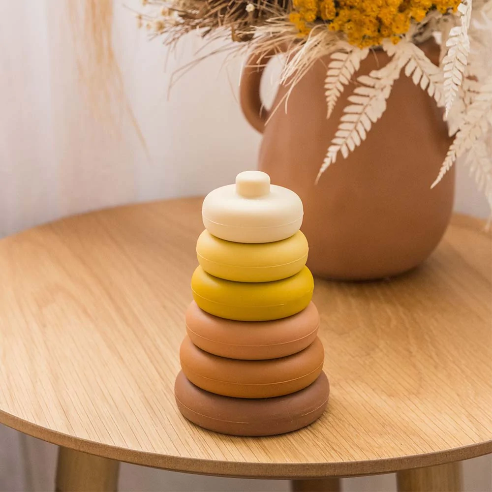 Stacking and Sensory Montessori Toy on the wooden table with flower behind
