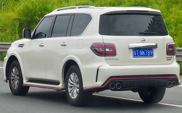 White Nissan Patrol with aftermarket exhaust on a road