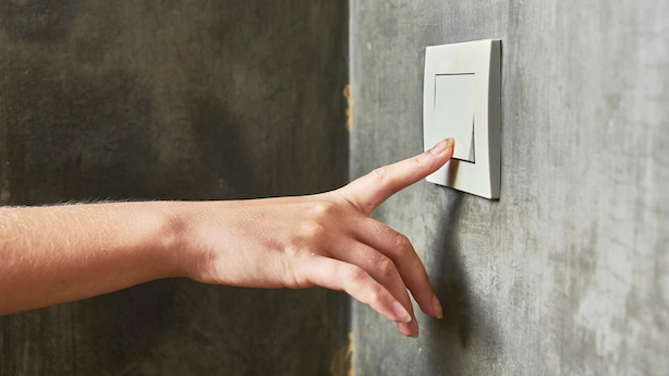 woman turning off light switch