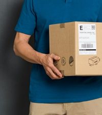 men holding box with shipping label on it